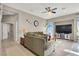 Bright living room with hardwood floors, large TV, and ceiling fan at 7291 Purple Shadow Ave, Las Vegas, NV 89113