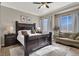 Main bedroom with king bed, sitting area, and large windows at 7291 Purple Shadow Ave, Las Vegas, NV 89113