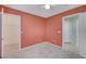 Coral walls and neutral carpeting in this well-lit bedroom with closet at 7978 Coronado Coast St, Las Vegas, NV 89139