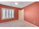 Bedroom with coral walls, ceiling fan, and large window with shutters at 7978 Coronado Coast St, Las Vegas, NV 89139