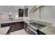 Kitchen with gas cooktop, granite counters, and dark cabinets at 7978 Coronado Coast St, Las Vegas, NV 89139