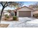 One-story house with tan exterior, red tile roof, and a two-car garage at 8016 Roundup Ridge St, Las Vegas, NV 89131