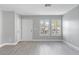 Living room with gray walls, light gray wood-look flooring, and white shutters at 8016 Roundup Ridge St, Las Vegas, NV 89131