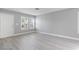 Living room with gray walls, light gray wood-look flooring, and white shutters at 8016 Roundup Ridge St, Las Vegas, NV 89131