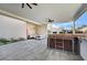 Outdoor kitchen with built-in appliances and seating area under covered patio at 8104 Via Del Cerro Ct, Las Vegas, NV 89117