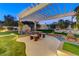 Evening view of a pergola-covered patio with seating and fountain at 8104 Via Del Cerro Ct, Las Vegas, NV 89117