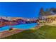 Backyard oasis with a large pool, waterfall, and outdoor kitchen at 8104 Via Del Cerro Ct, Las Vegas, NV 89117