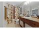 Charming bathroom with floral shower curtain and wooden vanity at 9048 Rich Amethyst Ct, Las Vegas, NV 89149