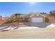 Single story home with a two car garage and desert landscaping at 9921 Heyfield Dr, Las Vegas, NV 89134