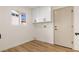 Laundry room with white cabinets and wood-look floors at 9921 Heyfield Dr, Las Vegas, NV 89134