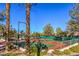 Community tennis courts with palm trees and fencing at 9921 Heyfield Dr, Las Vegas, NV 89134