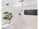 Modern bathroom with white tile, a glass block window, and a black accent at 2276 Ray Kanel Dr, Las Vegas, NV 89156