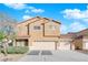 Beige two-story house, three car garage, and front yard landscaping at 2314 Rock Slide Cir, Las Vegas, NV 89115