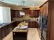 Large kitchen with granite countertop island, dark wood cabinets, and stainless steel appliances at 2438 Ping Drive, Henderson, NV 89074