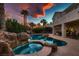 Stunning pool and spa area with rock waterfall feature at sunset at 3042 Hammerwood Dr, Las Vegas, NV 89135