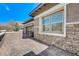 Brick and stone elevation with a gated side entrance and paved patio at 370 Mano Destra Ln, Henderson, NV 89011