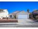 House exterior showcasing a tan stucco finish, red tile roof, and a two-car garage at 3704 Russian Olive St, North Las Vegas, NV 89032