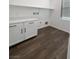 Laundry room with white cabinets and wood-look floors at 4372 Latitude Valley Ct, North Las Vegas, NV 89084