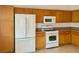 Kitchen boasts wood cabinets and modern white appliances at 5415 Thomaston Ct, Las Vegas, NV 89122