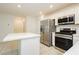 Kitchen island and stainless steel appliances in this modern kitchen at 675 Omaggio Pl, Henderson, NV 89011