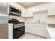 Modern kitchen with stainless steel appliances and white cabinetry at 675 Omaggio Pl, Henderson, NV 89011
