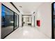 Modern hallway with white tile floors and a view of a bedroom with a fireplace at 7815 W La Madre Way, Las Vegas, NV 89149
