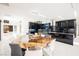 Modern kitchen with a large island, dark cabinetry, and a live-edge table at 7815 W La Madre Way, Las Vegas, NV 89149