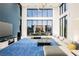 Open concept living area with blue carpet and large windows at 7815 W La Madre Way, Las Vegas, NV 89149