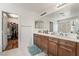 Bathroom with double vanity, two mirrors, and a walk-in closet at 9236 Arbor Glen St, Las Vegas, NV 89123