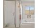 Bathroom featuring a separate shower, bathtub, and window with natural light at 9236 Arbor Glen St, Las Vegas, NV 89123