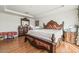 Ornate primary bedroom with hardwood floors, sitting bench, and dresser with matching mirror at 9236 Arbor Glen St, Las Vegas, NV 89123