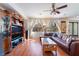 Living room features wood floors, ceiling fan, a large entertainment center and bright windows at 9236 Arbor Glen St, Las Vegas, NV 89123