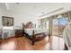 Main bedroom with hardwood floors, large bed, and bright windows with stylish drapes at 9236 Arbor Glen St, Las Vegas, NV 89123