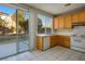 Kitchen with wood cabinets, white appliances, and backyard access at 10332 Splendor Ridge Ave, Las Vegas, NV 89135