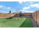 Landscaped backyard with artificial turf, a tree, and a seating area at 165 Arrow Point Ln, Henderson, NV 89011