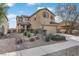 Two-story house with beige exterior, landscaped front yard, and attached garage at 165 Arrow Point Ln, Henderson, NV 89011