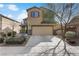 Tan two story house with attached garage and desert landscaping at 165 Arrow Point Ln, Henderson, NV 89011