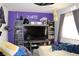 Bedroom with large TV and purple walls at 1764 Sunflower Ct, Henderson, NV 89074