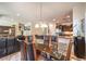 Bright dining room with glass-top table, dark chairs, and kitchen view at 2408 Sky Watcher St, Henderson, NV 89044