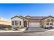 Tan two-story house with brown roof, attached garage, and landscaping at 2408 Sky Watcher St, Henderson, NV 89044