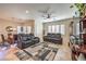 Open living and dining area with leather furniture, tiled floor, and large windows at 2408 Sky Watcher St, Henderson, NV 89044