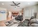 Living room with leather seating, kitchen view, and ceiling fan at 2408 Sky Watcher St, Henderson, NV 89044