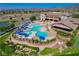 Aerial view of a resort style pool with lounge chairs, blue umbrellas and beautiful landscaping at 2429 Anderson Park Dr, Henderson, NV 89044