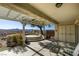 A covered back patio with concrete floor and a raised seating area features lovely desert and mountain views at 2429 Anderson Park Dr, Henderson, NV 89044