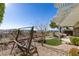 Backyard featuring a covered patio, gravel ground cover, a swing bench, and mountain views at 2429 Anderson Park Dr, Henderson, NV 89044