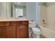 Bathroom with wood vanity, a toilet, and a tub/shower with a white shower curtain, all in a modern style at 2429 Anderson Park Dr, Henderson, NV 89044