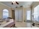 Bedroom featuring tile flooring, ceiling fan, large windows, and a sliding door closet with mirrored doors at 2429 Anderson Park Dr, Henderson, NV 89044