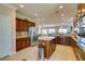 Open kitchen featuring an island, stone countertops, custom wood cabinetry, and stainless steel appliances at 2429 Anderson Park Dr, Henderson, NV 89044