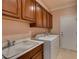 Laundry room featuring a utility sink, cabinets, and a washer and dryer with a door leading outside at 2429 Anderson Park Dr, Henderson, NV 89044