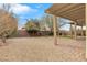 Landscaped backyard with gravel, trees, and a covered patio at 2571 Hazelburn Ave, Henderson, NV 89044